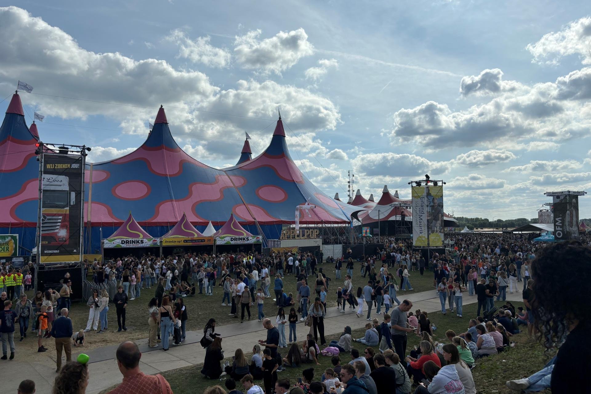 Enorm grote festivaltent op de voorgrond, er achter nog een grote tent, Veel mensen op de Waalkade